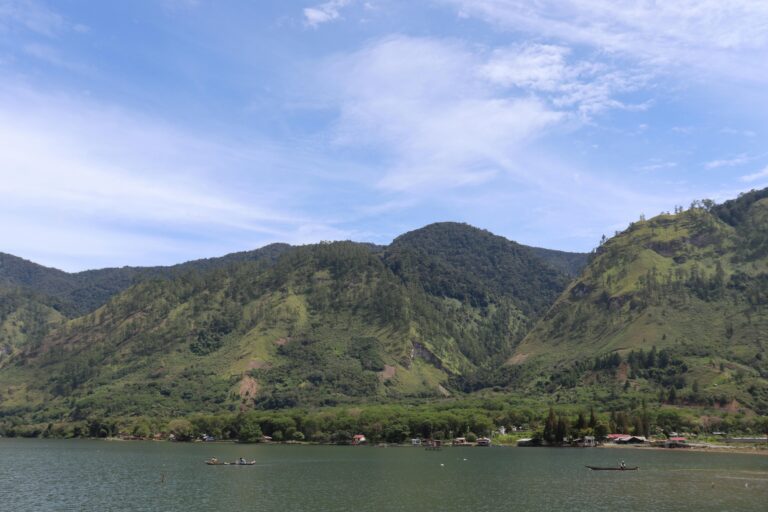 Beautiful landscape of Lake Laut Tawar surrounded by lush green hills in Takengon, Aceh, Indonesia.